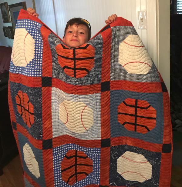 Debbie Outlaw's grandson Jackson with quilt